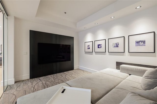 carpeted living room with a tray ceiling