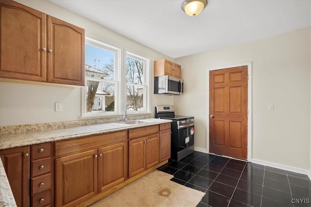 kitchen with dark tile patterned flooring, sink, and stainless steel appliances