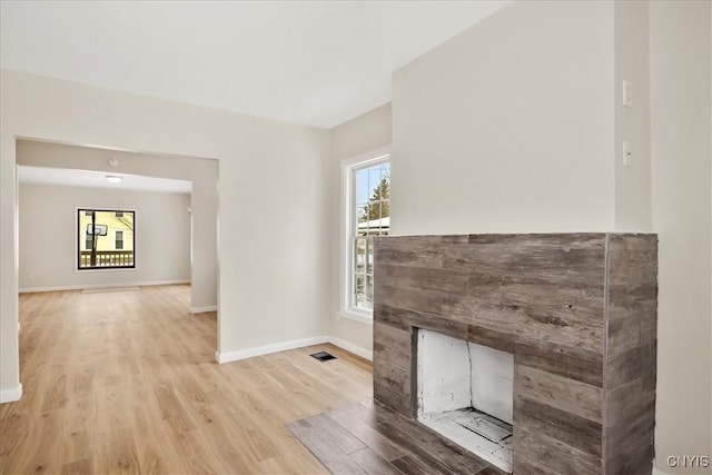 unfurnished living room featuring a fireplace and light hardwood / wood-style floors