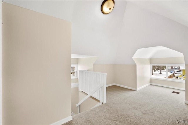 bonus room with vaulted ceiling and carpet flooring