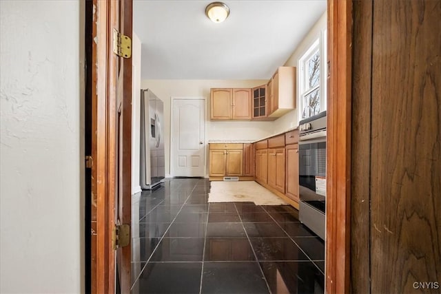 kitchen featuring light brown cabinetry and stainless steel fridge with ice dispenser