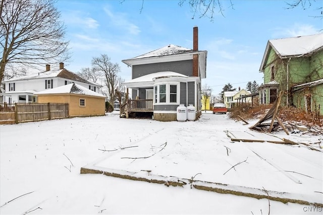 view of snow covered back of property