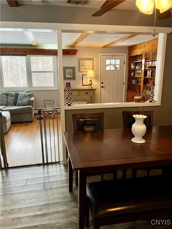 dining space featuring beam ceiling and hardwood / wood-style flooring