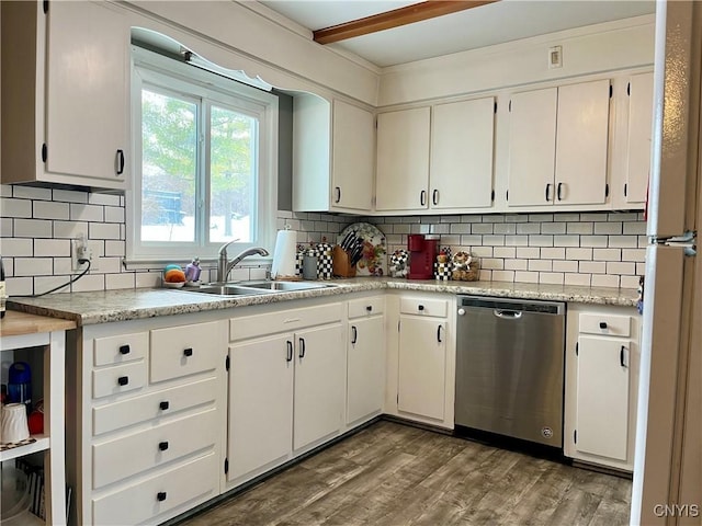 kitchen with backsplash, hardwood / wood-style floors, stainless steel dishwasher, sink, and white cabinetry