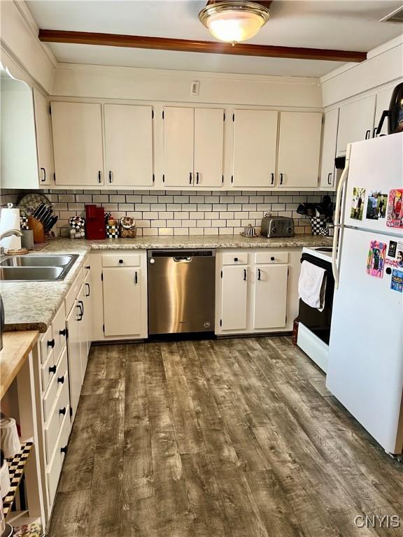 kitchen featuring backsplash, dark hardwood / wood-style floors, white appliances, beam ceiling, and sink