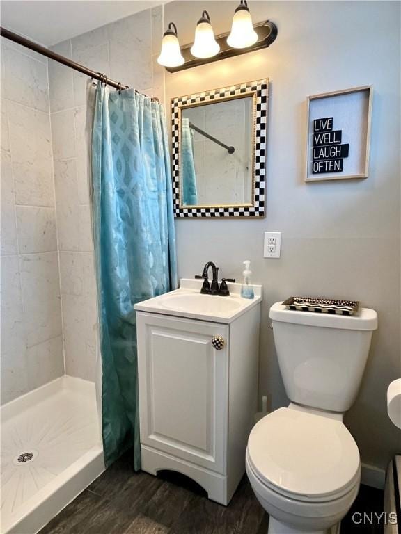 bathroom featuring toilet, vanity, hardwood / wood-style flooring, and curtained shower