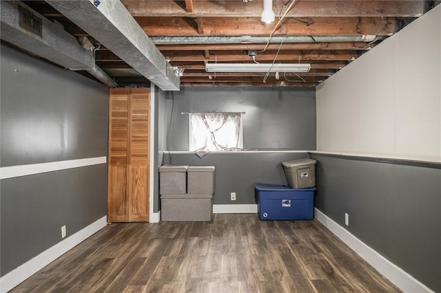 basement with dark hardwood / wood-style floors