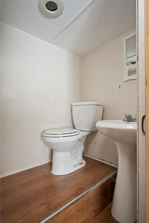 bathroom with toilet and hardwood / wood-style floors