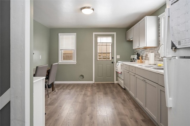 laundry room featuring light wood-type flooring and sink