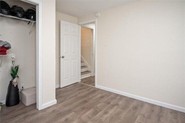 unfurnished bedroom with a closet and hardwood / wood-style floors