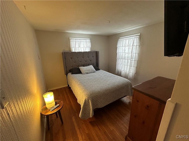 bedroom with dark hardwood / wood-style flooring