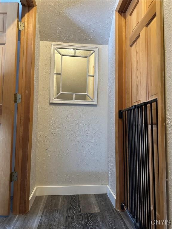 hall featuring a textured ceiling and dark hardwood / wood-style flooring