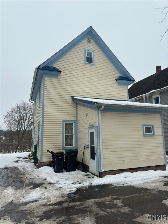 view of snow covered rear of property