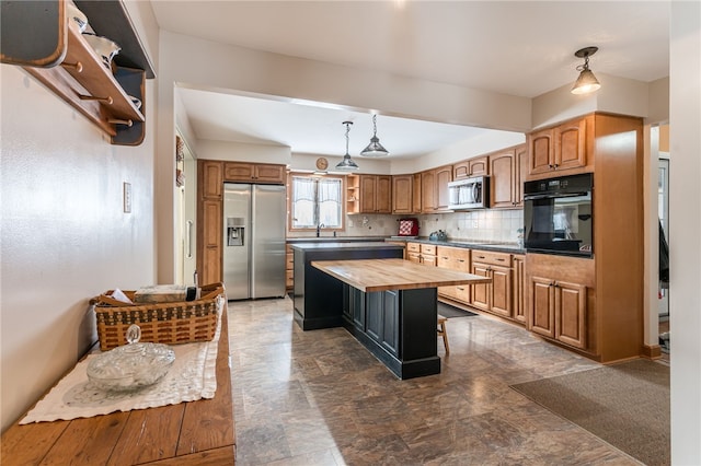 kitchen with black appliances, a center island, wood counters, decorative backsplash, and hanging light fixtures