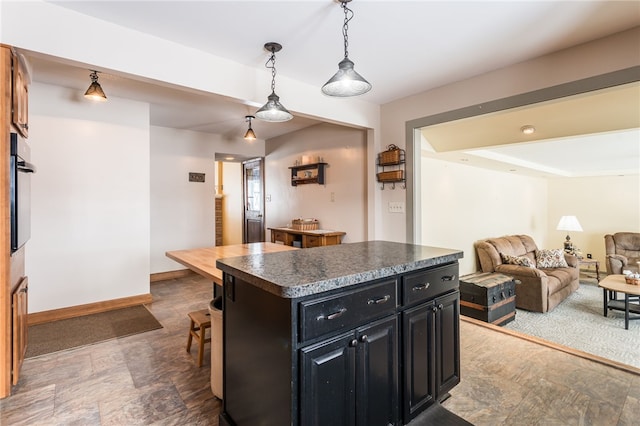 kitchen featuring wall oven, a kitchen island, and pendant lighting