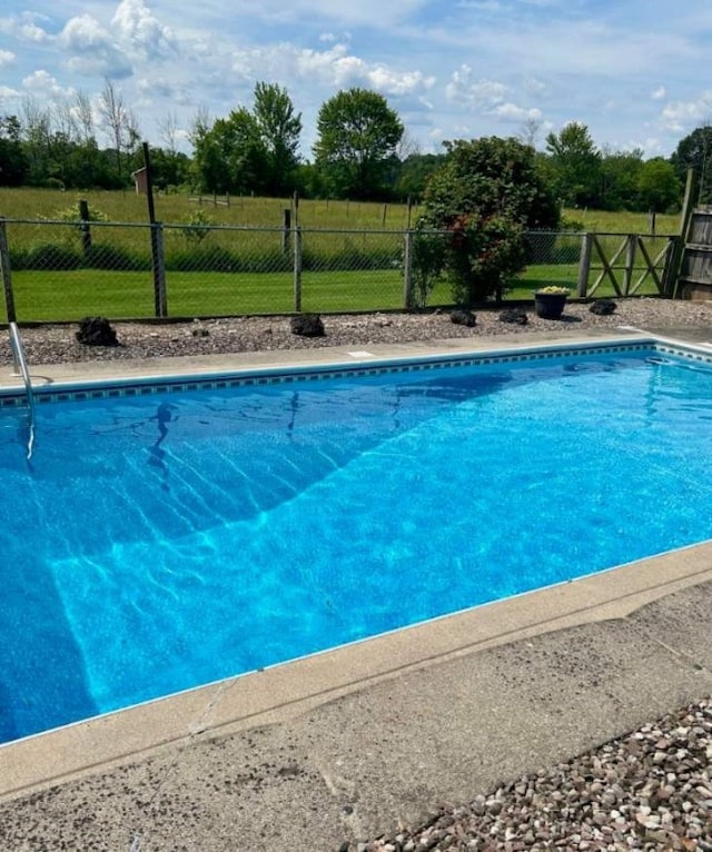 view of pool with a lawn