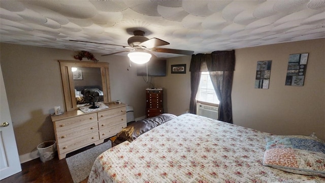 bedroom with ceiling fan, cooling unit, and dark hardwood / wood-style flooring