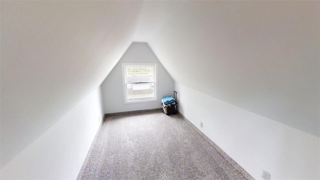 additional living space featuring lofted ceiling and light colored carpet