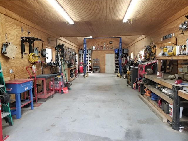 garage featuring a workshop area, wooden walls, and wooden ceiling