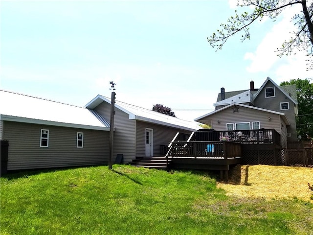 back of house featuring a deck and a lawn