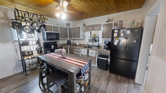 kitchen with hardwood / wood-style floors, black appliances, sink, crown molding, and wood ceiling