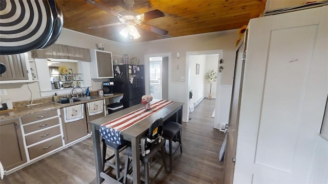 kitchen with black refrigerator, ceiling fan, dark hardwood / wood-style floors, and wooden ceiling