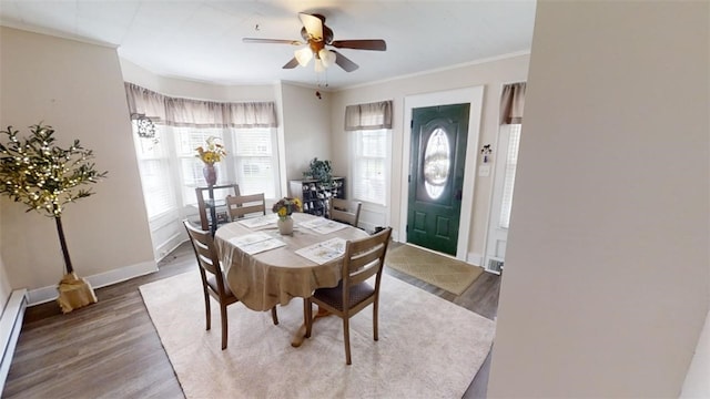 dining space with baseboard heating, ornamental molding, hardwood / wood-style floors, and ceiling fan