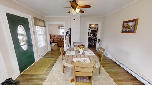 dining area with ceiling fan, a baseboard heating unit, crown molding, and hardwood / wood-style flooring