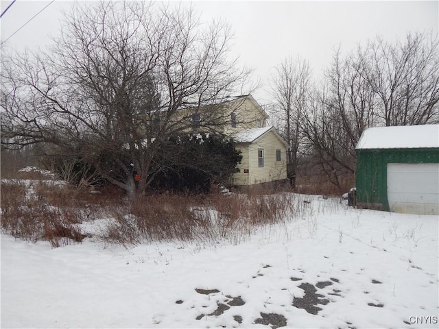 yard covered in snow featuring a garage