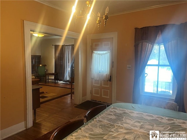 bedroom featuring crown molding, wood-type flooring, and a notable chandelier