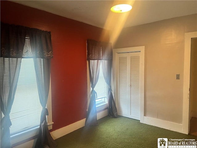 unfurnished bedroom featuring a closet and dark carpet