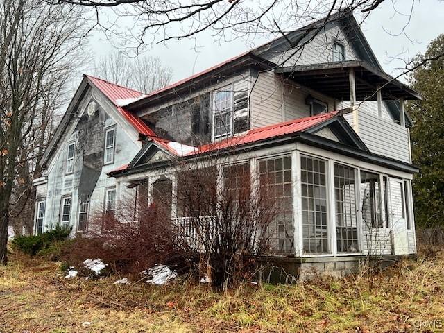 view of side of home featuring a sunroom