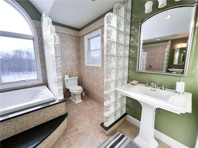 bathroom featuring toilet, tile patterned floors, and a bathing tub