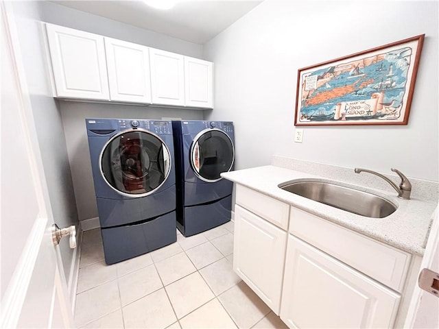 clothes washing area featuring cabinets, light tile patterned floors, washer and clothes dryer, and sink