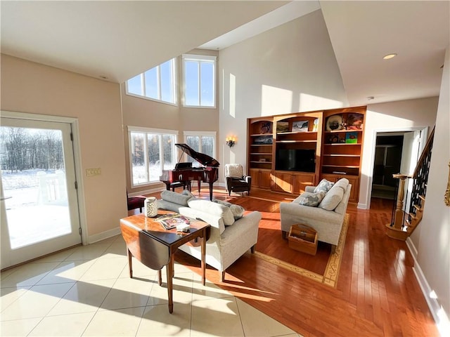 living room featuring a healthy amount of sunlight, light tile patterned flooring, and a high ceiling