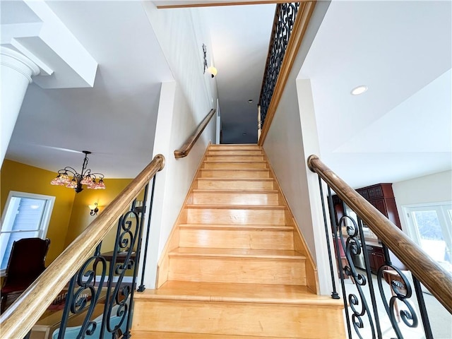 stairs with an inviting chandelier