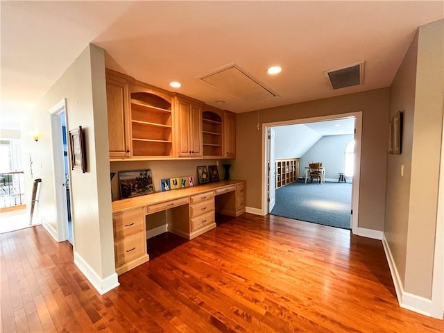 kitchen featuring hardwood / wood-style floors, lofted ceiling, butcher block counters, and built in desk