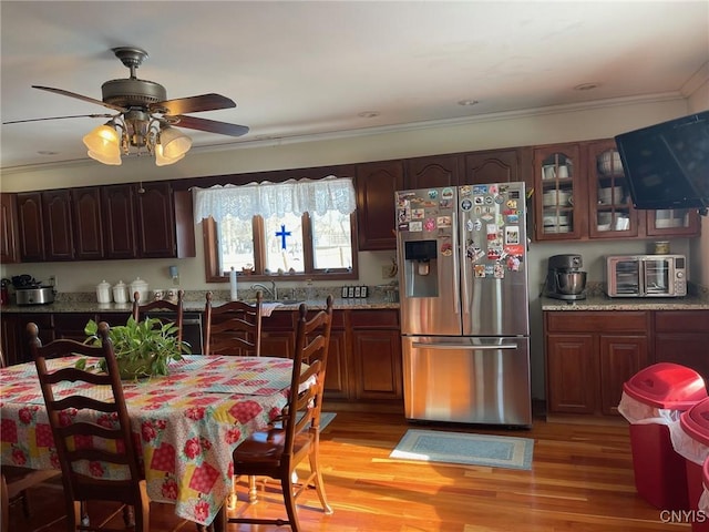 kitchen with ceiling fan, light stone countertops, stainless steel fridge, and light hardwood / wood-style flooring