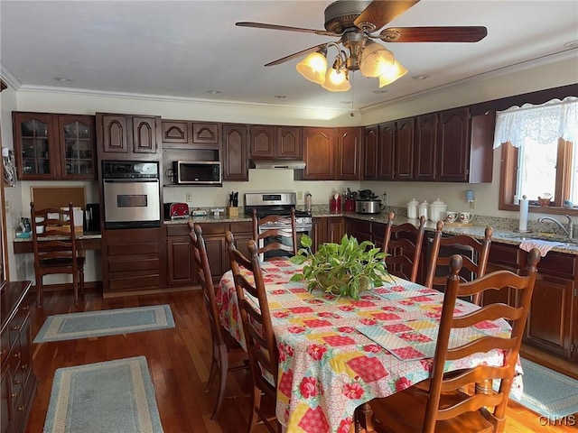 dining area featuring ceiling fan, dark wood-type flooring, and ornamental molding