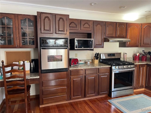 kitchen featuring built in desk, light stone counters, stainless steel appliances, and ornamental molding