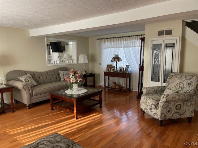 living room with a textured ceiling and hardwood / wood-style flooring