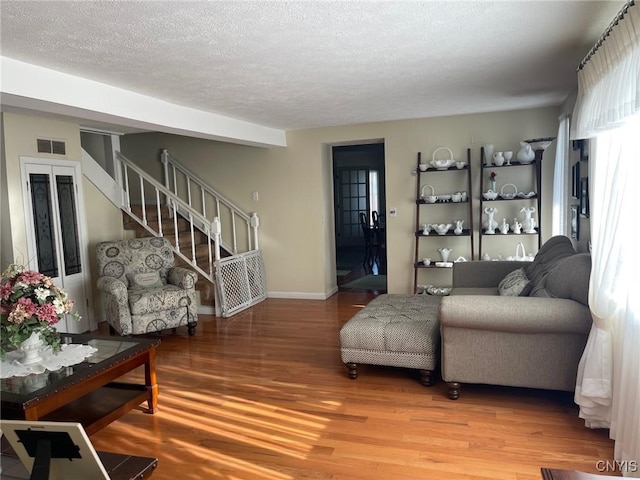 living room featuring a textured ceiling and hardwood / wood-style floors