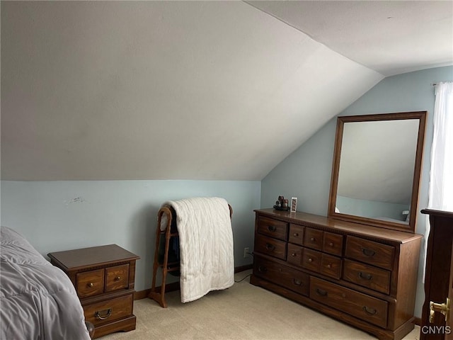 bedroom with light colored carpet and lofted ceiling