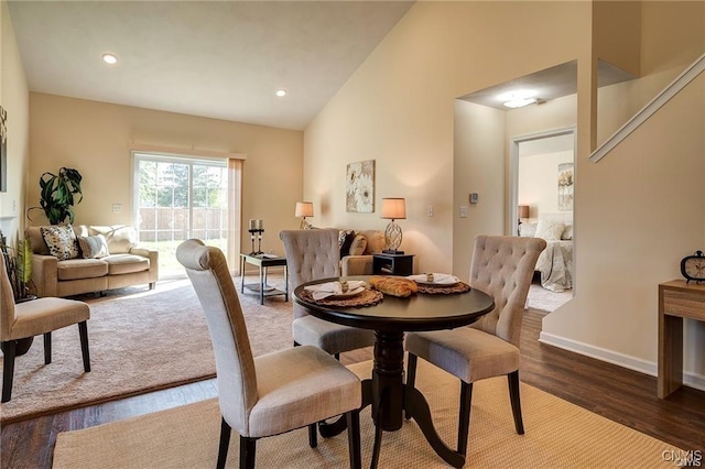 dining area with hardwood / wood-style floors and high vaulted ceiling