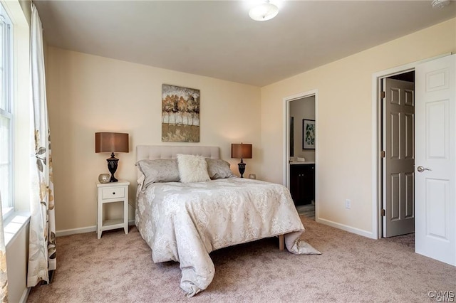 carpeted bedroom featuring ensuite bath