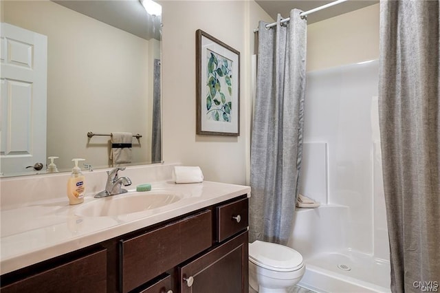 bathroom featuring toilet, vanity, and walk in shower