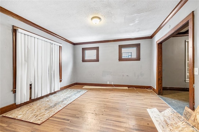 interior space with a textured ceiling, light hardwood / wood-style flooring, and crown molding