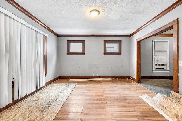 interior space featuring a textured ceiling, crown molding, and hardwood / wood-style flooring