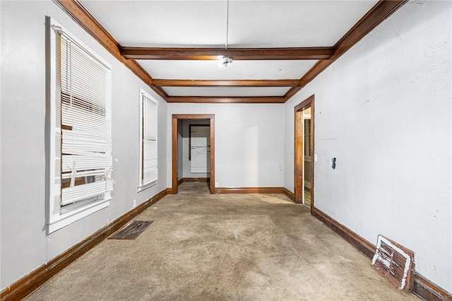 spare room featuring light colored carpet and beam ceiling