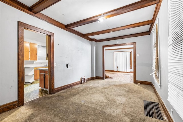 carpeted empty room with ornamental molding, coffered ceiling, and beamed ceiling